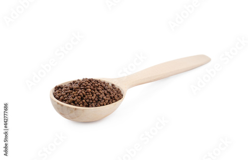 Wooden spoon with buckwheat tea granules on white background