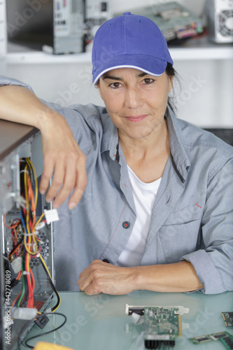 female pc technician posing by a computer