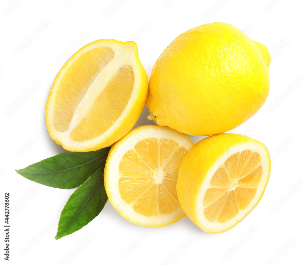 Cut and whole ripe lemons with green leaves on white background, top view