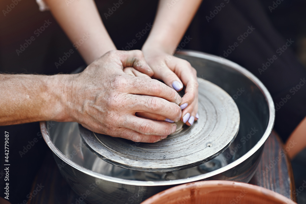 People making a vaze from a clay on a pottery's machine People making a vaze from a clay on a pottery's machine