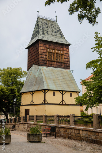 Rakovnik, Central Bohemian region, Czech Republic, 19 June 2021: Church of St. Bartholomew with Large bell tower with half-timbered floor at main Husove Square at summer day, entrance gothic portal photo