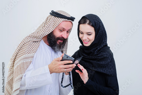 Portrait of Arabic way dressed couple play with mobile phone