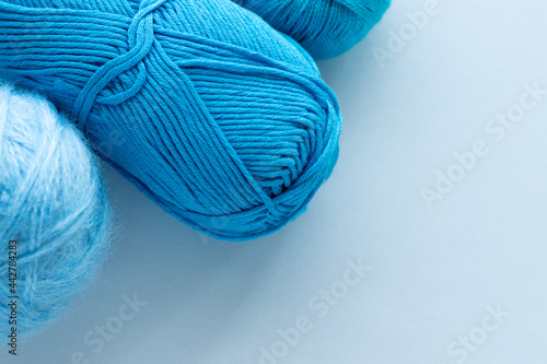Clews of woolen nylon or acrylic yarn for knitting for handmade or hobbies lie in the corner of the frame and copy space blank or mockup for design and inscriptions with text