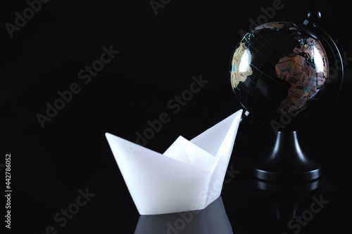 Wallpaper Mural A white ship on a black background with a globe. Travel around the world by ship. Torontodigital.ca