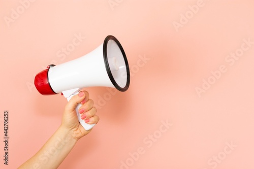 Woman holding megaphone on pink background