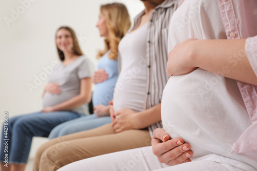 Group of pregnant women at courses for expectant mothers indoors, closeup