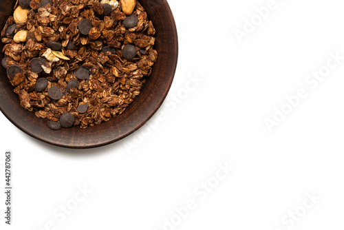 Chocolate granola cereal with nuts in a bowl background. © Nikolay