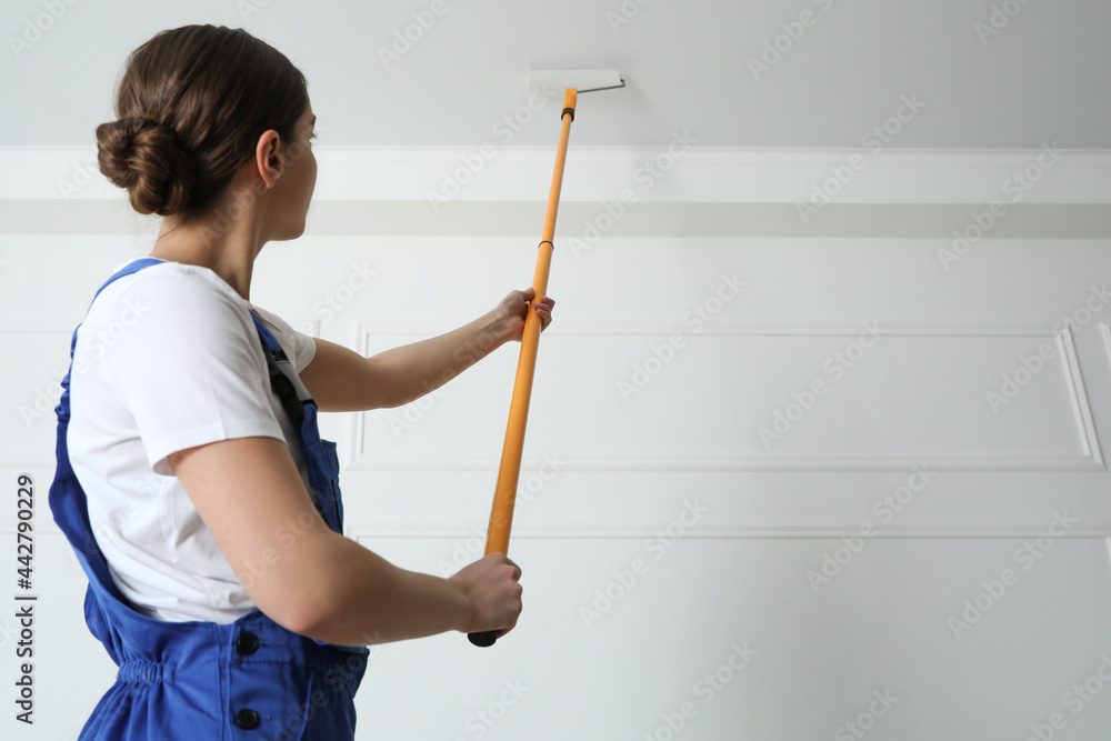 Worker painting ceiling with white dye indoors, back view. Space for text Worker painting ceiling with white dye indoors, back view. Space for text