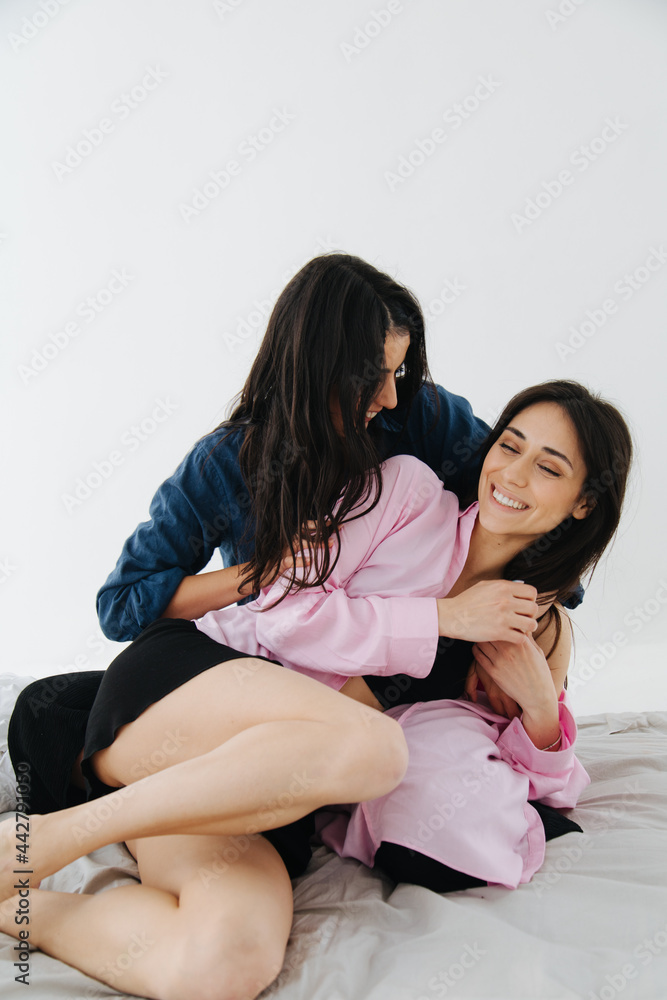 armenian woman embracing smiling friend in bedroom armenian woman embracing smiling friend in bedroom
