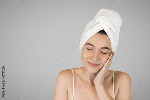 Washing your face. Closeup of woman cleaning skin with towel portrait. The woman touches her skin with her hands and smiles. High quality studio shot. 