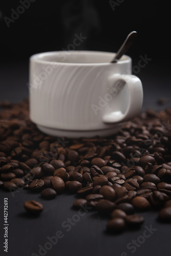 Coffee mug with spoon isolated on coffee background