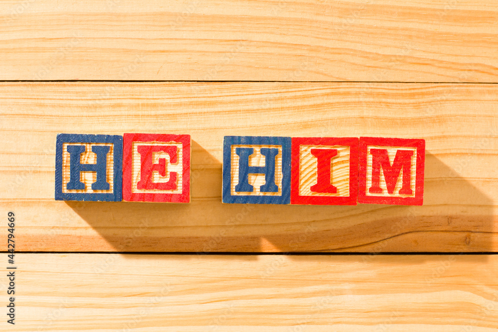 Spectacular wooden cubes with the word HE HIM on a wooden surface. - obrazy, fototapety, plakaty 