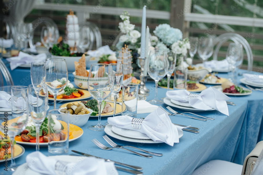 Two tables setting for an event on a terrace. Empty plates with napkins