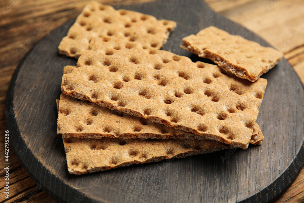 Board with fresh rye crispbreads on wooden table, closeup Board with fresh rye crispbreads on wooden table, closeup