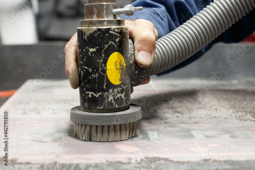 Photos Male hand of a granite workshop worker with a dustless sandblaster