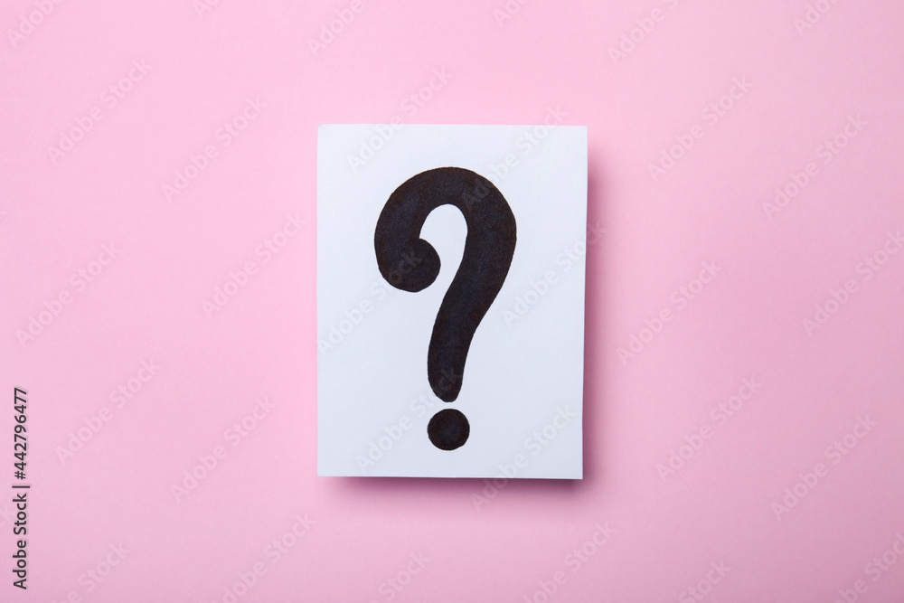 Paper card with question mark on pink background. Question and answer concept, top view Paper card with question mark on pink background. Question and answer concept, top view