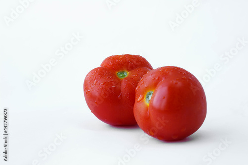 red tomatoes with water drops, two tomatoes, tomatoes on a white background