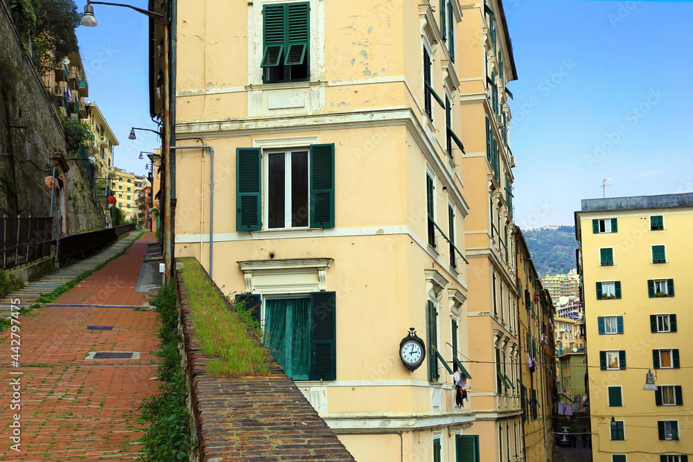 View of a typical narrow and uphill Genoa route (CrÃªuza in genoese language) lined with ancient buildings. Laterally there is the Granarolo funicular. Genoa, Italy.