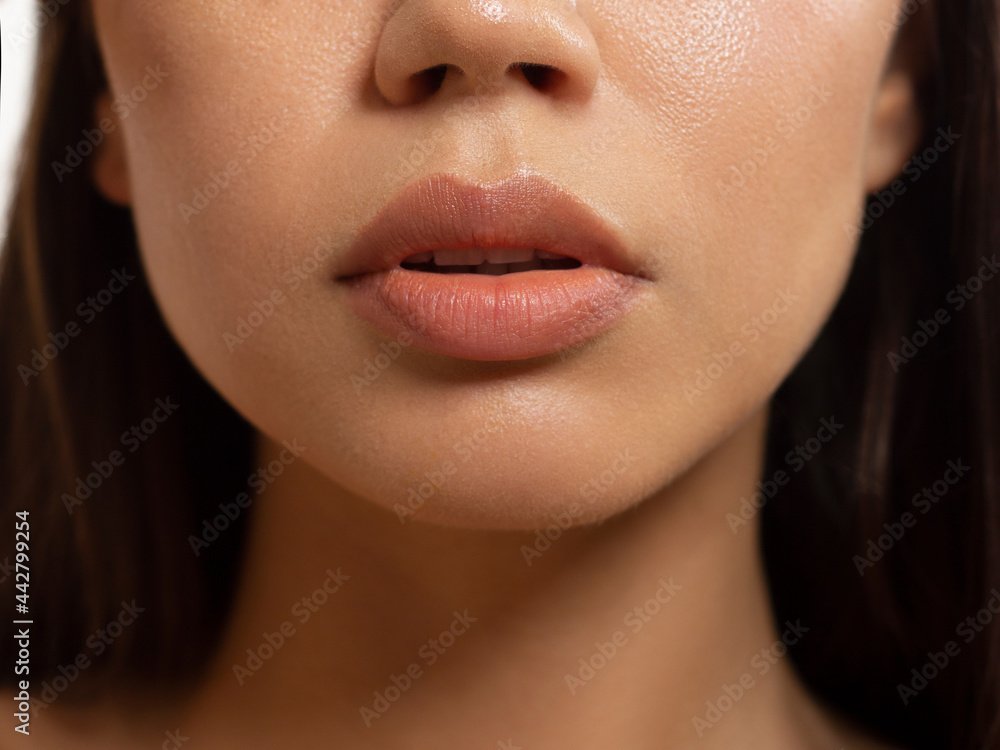 Close-up of woman's lips with fashion natural beige lipstick makeup. Macro  sexy pale lipgloss make-up . Gentle pure skin and wavy brunet hair.  Cosmetology, Spa, increase in lips Stock Photo | Adobe