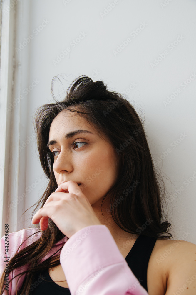 dreamy armenian woman looking away while holding hand near face