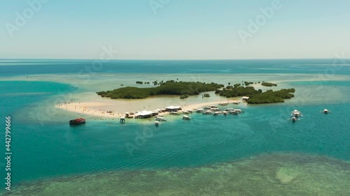 Tropical Luli island and sandy beach with tourists surrounded by coral reef and blue sea in honda bay, aerial view. Island with sand bar and coral reef. Summer and travel vacation concept, Philippines photo