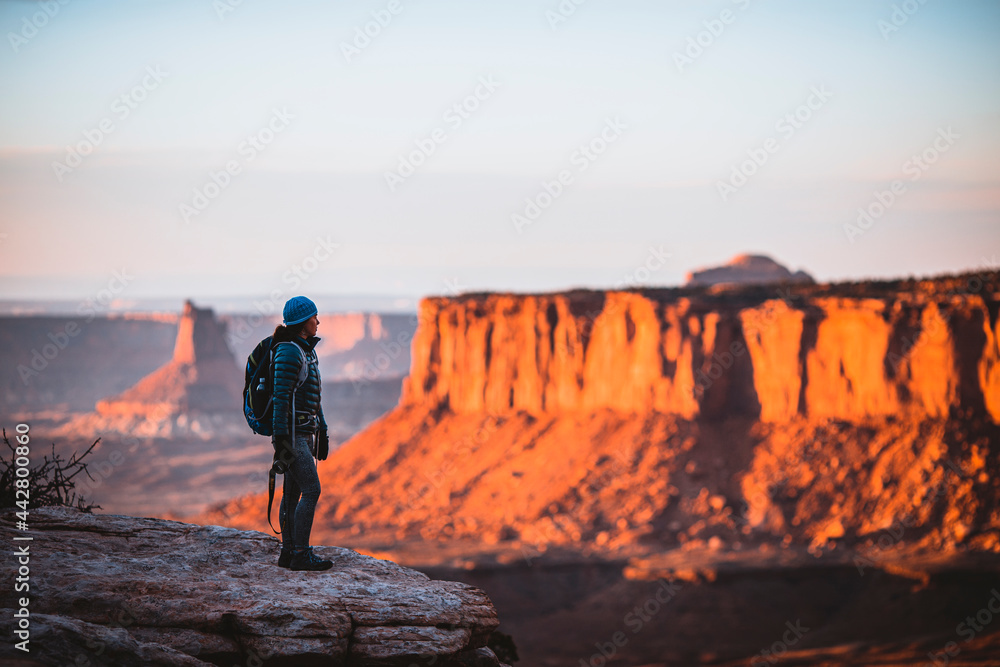 female hiker looks out over Canyonlands National Park at sunset, Utah female hiker looks out over Canyonlands National Park at sunset, Utah