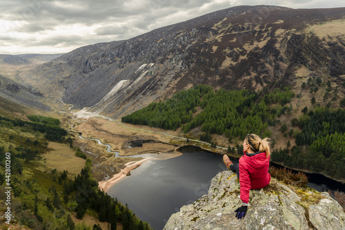 A woman traveler in a red jacket in the Spink Viewing Spot in Wicklow
