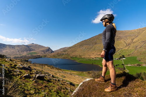 Female cyclist admiring mountainous scenery at Gap of Dunloe Kerry mou photo