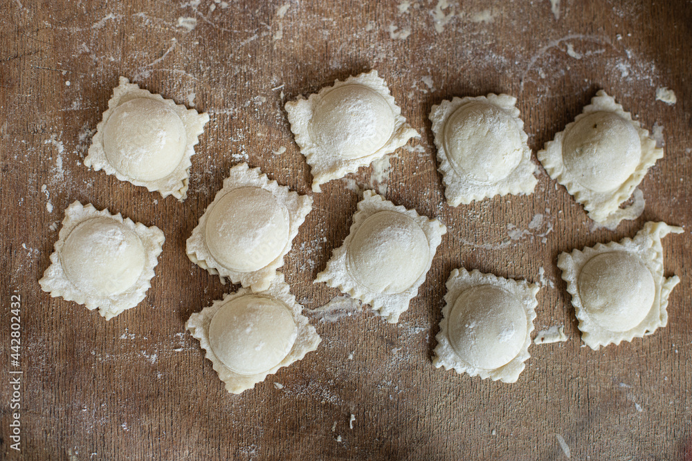 stuffed ravioli raw dough and filling square dumplings on the table, healthy food meal snack copy space food background rustic. top view stuffed ravioli raw dough and filling square dumplings on the table, healthy food meal snack copy space food background rustic. top view