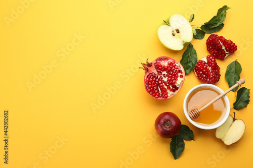 Flat lay composition with Rosh Hashanah holiday attributes on yellow background. Space for text photo