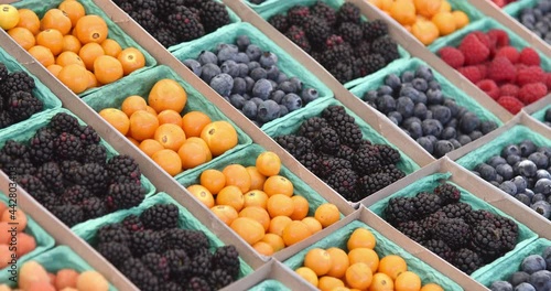 Containers of fresh organic berries at a farmers market

