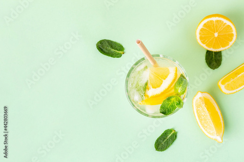 Fotografia, Obraz Ice lemon water or lemonade with mint on a green background