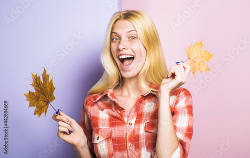 Autumn mood. Smiling woman with maple leaves. Fashion trends for fall. Happy girl with yellow leaves.