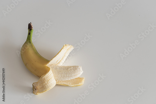 Banana on the white table. Food background. Minimalistic wallpaper