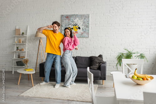 smiling young couple in casual clothes dancing in modern loft © LIGHTFIELD STUDIOS