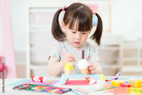 young girl decorating hand made craft for homeschooling