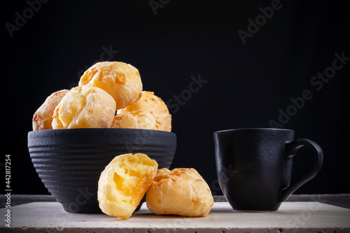 delicious cheese breads and a cup of coffee on white marble with black background photo