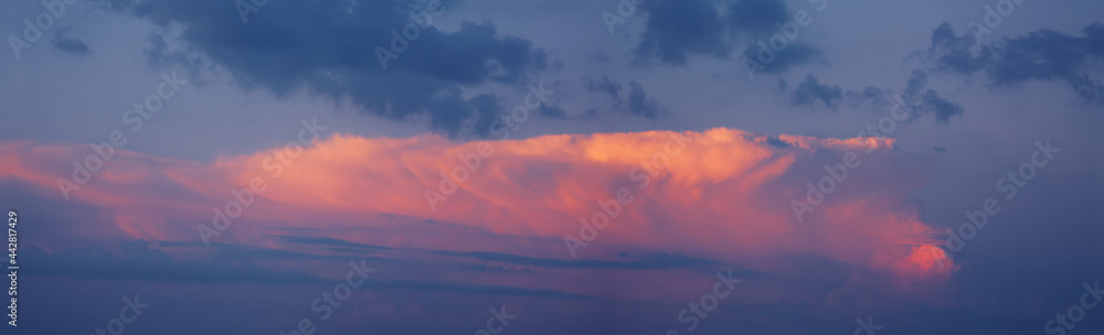 Panorama of the sky at sunset. A cloud illuminated by the setting sun. The sky at dusk. Panorama of the sky at sunset. A cloud illuminated by the setting sun. The sky at dusk.
