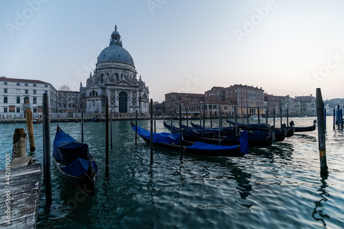 Venetian gondola at sunset, gondolas moored in Venice with Santa Maria della Salute basilica in the background, Italy © Marcin Rogozinski