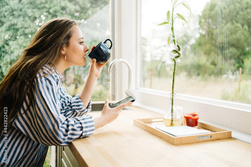 side view of young millennial creating content in her kitchen side view of young millennial creating content in her kitchen