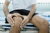 knee pain, a man sitting on a bed during his physiotherapy