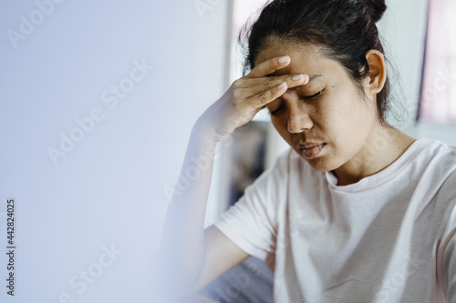 young asian woman hold the head with hand due to headache