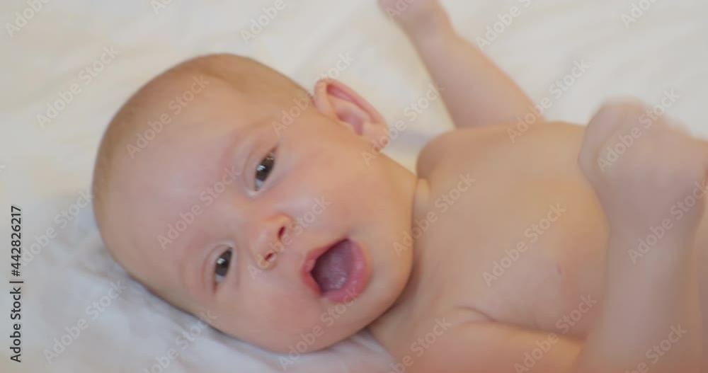 portrait of a modern child. cute baby infant lies in bed. close-up. portrait of a modern child. cute baby infant lies in bed. close-up.