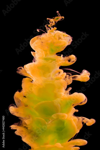Yellow-green paint in water isolated on black background