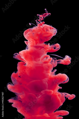 Red paint in water isolated on black background
