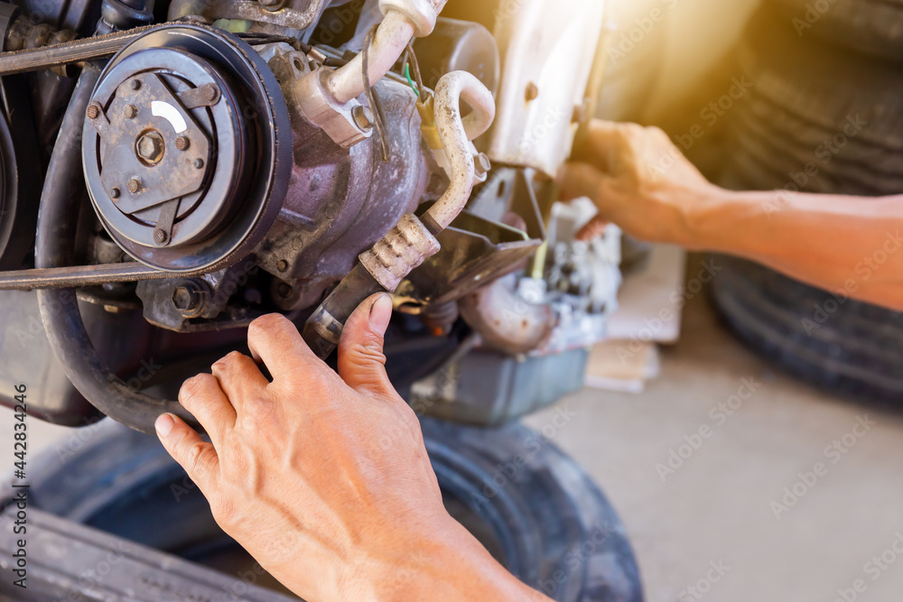 Hands of Auto mechanic working on car engine in mechanics garage, Repair and Maintenance service Hands of Auto mechanic working on car engine in mechanics garage, Repair and Maintenance service