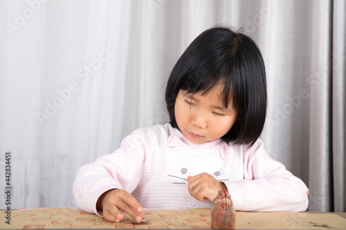 Cute Chinese girl checking her seal on rice paper