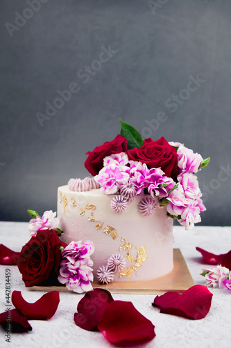 Fototapeta Naklejka Na Ścianę i Meble -  Beautiful Wedding cake with flowers on table and black background.