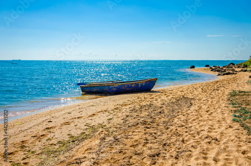 A fishing boat is standing on the seashore.A deserted sea beach.