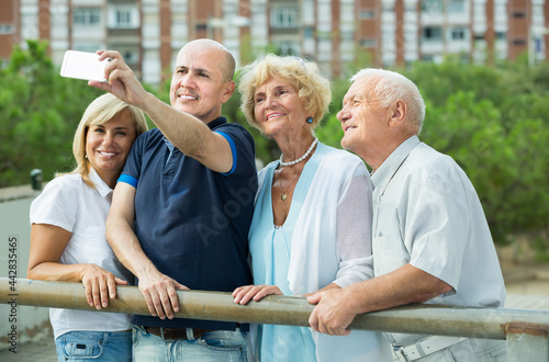 Group of smiling mature people taking selfie in the garden outdoor